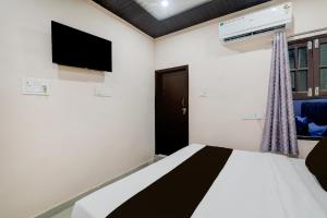 a bedroom with a bed and a flat screen tv at Hotel O Shri Buddheshwar Temple Lucknow in Alambagh