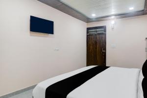a bedroom with a bed and a tv on the wall at Hotel O Shri Buddheshwar Temple Lucknow in Alambagh +34 photos
