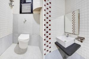 a white bathroom with a toilet and a sink at Collection O Shendra MIDC Aurangabad Formerly Sai Palace in Aurangabad