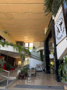 a lobby of a building with plants on the side at Bantay Viajeros Inn in San Julian Norte