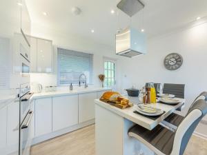 a kitchen with white cabinets and a table and chairs at River View Cottage in Berwick-Upon-Tweed +15 photos