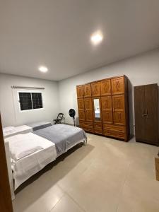 a bedroom with a large bed and wooden cabinets at Casa 3 Suites Confortaveis in Chapada dos Guimarães