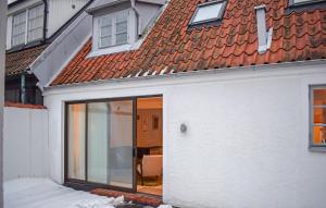 a white house with a sliding glass door at 3 Bedroom Nice Home In Simrishamn in Simrishamn +16 photos