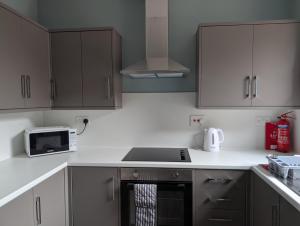 a kitchen with white cabinets and a stove top oven at Argyll Place in Campbeltown