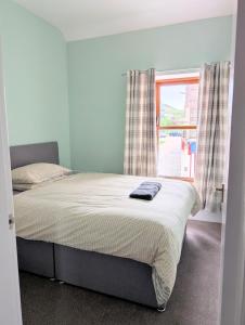 a bedroom with a large bed with a window at Argyll Place in Campbeltown