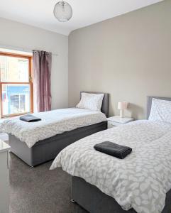 a bedroom with two beds and a window at Argyll Place in Campbeltown +2 photos