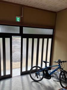a bike parked in front of a room with doors at Edo house in Shiigi +8 photos