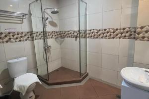 a bathroom with a shower and a toilet and a sink at Aamina Syariah Balikpapan in Klandasan-besar
