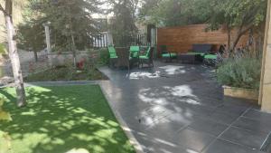 a patio with chairs and tables in a backyard at Panoramic 3-Bedroom Chalet with Terrace-Garden in Kfardebian