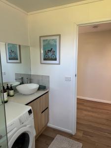 a bathroom with a washing machine and a sink at The Grain Shed in Euroa