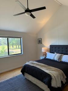 a bedroom with a bed and a ceiling fan at The Grain Shed in Euroa