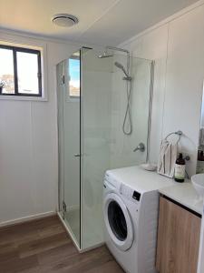 a washing machine in a bathroom with a shower at The Grain Shed in Euroa