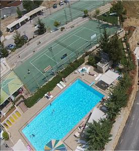 an overhead view of a tennis court and a swimming pool at Panoramic 3-Bedroom Chalet with Terrace-Garden in Kfardebian