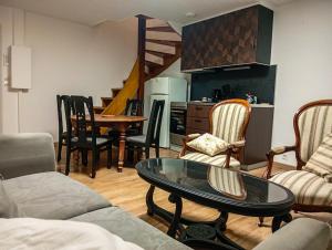 a living room with a table and chairs and a kitchen at Duplex vue sur château in Clisson