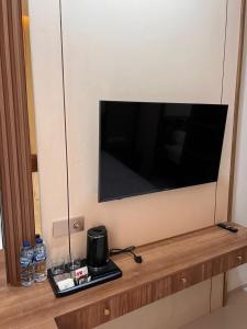 a television on a wall in a room at Pavo Guest House in Minangkabau International Airport