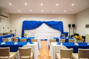 a room with blue tables and chairs and a stage at Microtel by Wyndham Cabanatuan in Cabanatuan +80 photos