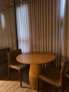 a wooden table and two chairs next to a window at Loft de Luxo com Charme e Design Moderno in Cuiabá +33 photos