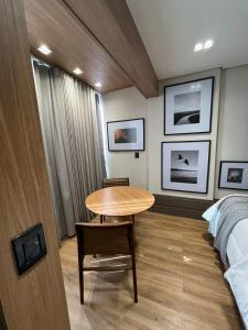 a small room with a table and a bed at Loft de Luxo com Charme e Design Moderno in Cuiabá
