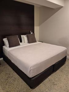a bedroom with a large bed with white sheets and pillows at Sovereign Resort Hotel in Cooktown +36 photos