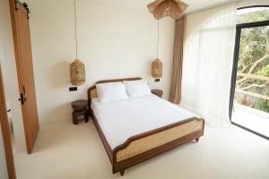 a bedroom with a bed and a window at Tyde Bali Boutique Hotel in Uluwatu