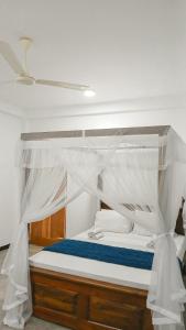 a bed with a canopy in a room at The White Crane Koggala in Habaraduwa Central