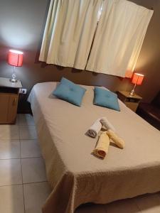 a bed with two towels and two lamps on it at Suite's on the rock's in Nono +31 photos