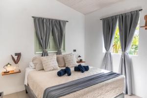 a bedroom with a bed with two blue pillows at KAIA VILLAGE, Santa Teresa, Costa Rica in Santa Teresa Beach +96 photos
