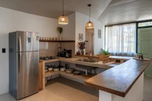 a kitchen with a stainless steel refrigerator and a sink at KAIA VILLAGE, Santa Teresa, Costa Rica in Santa Teresa Beach