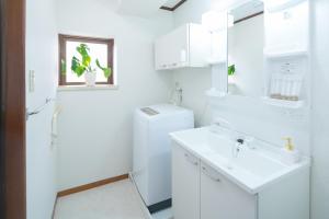 a white bathroom with a sink and a toilet at 禅 Zen 鹿児島 フロア貸切 中央駅徒歩14分 in Yamashitachō +109 photos