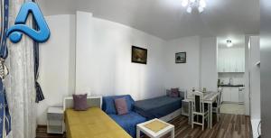 a small apartment with a blue couch and a kitchen at Adam's Apartment 2 in Kladovo