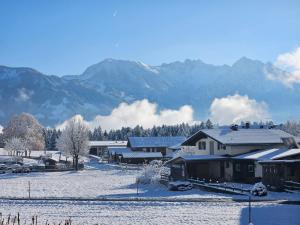a snow covered village with mountains in the background at Apartment Rubihornblick - mit Hallenbad und Sauna in Bolsterlang +4 photos