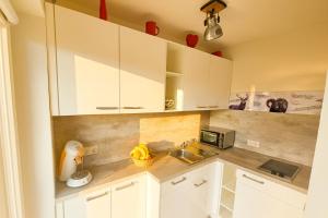 a kitchen with white cabinets and a sink at Apartment Rubihornblick - mit Hallenbad und Sauna in Bolsterlang