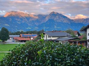 a town with mountains in the background with houses and trees at Apartment Rubihornblick - mit Hallenbad und Sauna in Bolsterlang