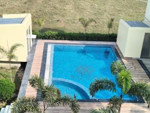 a swimming pool in a yard with a wooden deck at Mayabon Resort Bolpur in Shānti Niketan
