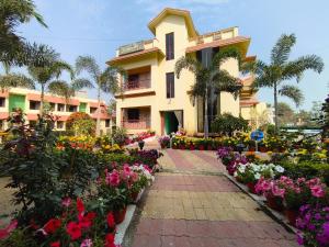 a building with flowers in front of it at Mayabon Resort Bolpur in Shānti Niketan