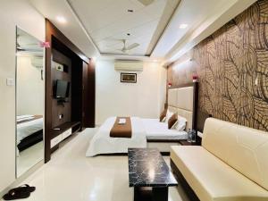a hotel room with two beds and a couch at Lijoy Hotel & Restra in Būndi +48 photos