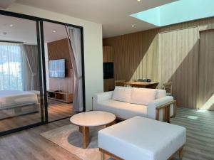 ein Wohnzimmer mit Sofa und Bett in der Unterkunft The Clover in Chiang Mai