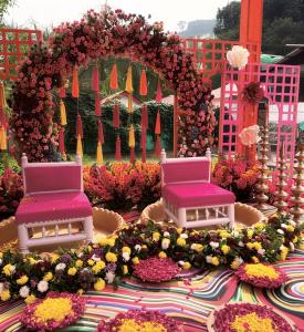 a table with two chairs and flowers on it at Qcent Bairagarh Resort Rishikesh in Mohan Chatti +50 photos