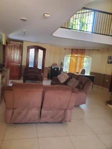 a living room with a brown couch and chairs at Casona Blanca Guesthouse in Chinandega