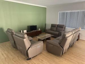 a living room with a couch and a table and chairs at Beach House Shared in Alkimos