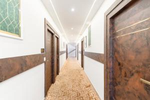 a corridor of an empty room with a wooden door at Treebo Skyline in Mangalore