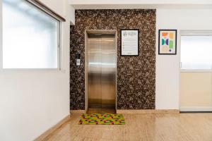 an elevator in a room with a colorful rug on the floor at Treebo Skyline in Mangalore +34 photos