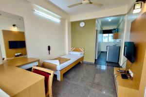 a hotel room with a bed and a tv at Visaara Luxury Homes in Kammasandra