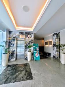a lobby with potted plants and a clock on the wall at Aamina Syariah Balikpapan in Klandasan-besar