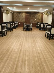 a large room with chairs and tables and wooden floors at Lijoy Hotel & Restra in Būndi