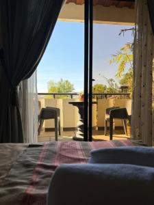 a bedroom with a bed and a view of a balcony at Bantay Viajeros Inn in San Julian Norte
