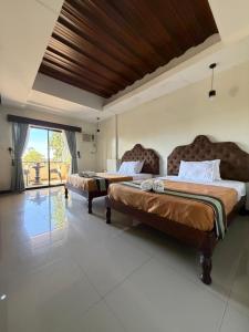 a bedroom with two beds and a large window at Bantay Viajeros Inn in San Julian Norte