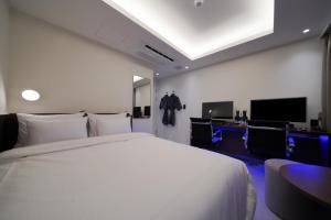 a bedroom with a large white bed and a television at Incheon No25 Hotel Seogu in Incheon