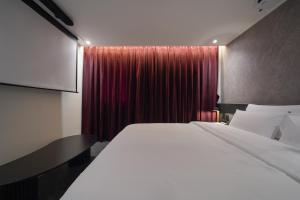 a bedroom with a large bed and a red curtain at Incheon No25 Hotel Seogu in Incheon