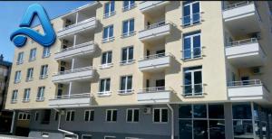 a large apartment building with a synergy sign on it at Adam's Apartment 2 in Kladovo